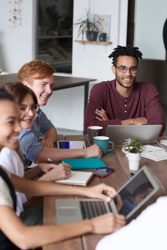A diverse group of professionals collaborate on laptops at a modern workplace, exhibiting teamwork and innovation.